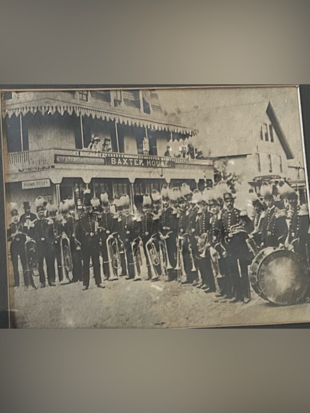Antique framed photo marching band outside Baxter Hotel.